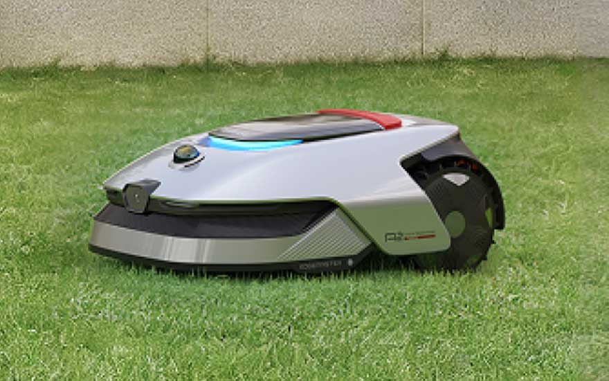 Een slimme robotmaaier rijdt over groen gras langs een muur, met een strak zilvergrijs ontwerp en gekleurde details.