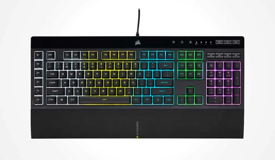 Corsair gaming keyboard with wrist rest, RGB zones in yellow, green and purple, and extra macro and media keys above the numpad.