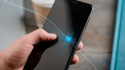 Hand houdt smartphone vast met eSIM-visualisatie en digitale netwerkverbindingen zichtbaar in futuristische weergave.