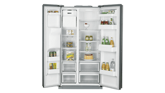 Een open, grijze koelkast met twee deuren onthult witte planken vol eten en drinken.