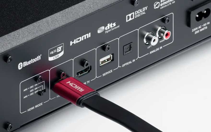 Close-up van achterkant audiotoestel met HDMI-kabel, Bluetooth, optische ingang, analoge poorten en Dolby-logo’s.