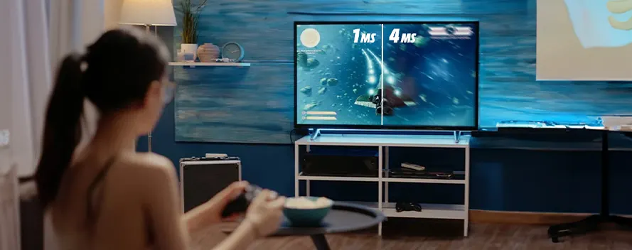 Vrouw speelt computerspel op groot tv-scherm. Console op wit meubel. Ze houdt een controller vast. Kom met eten op tafel.