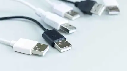 Witte en zwarte USB-kabels liggen op een witte achtergrond. De kabels zijn afwisselend wit en zwart.