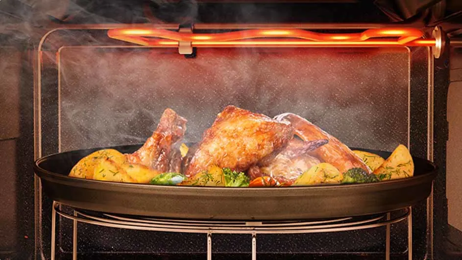 Oven met braadstuk, aardappelen en groenten in een pan op een rooster. Verwarmingsspiraal gloeit boven het gerecht.