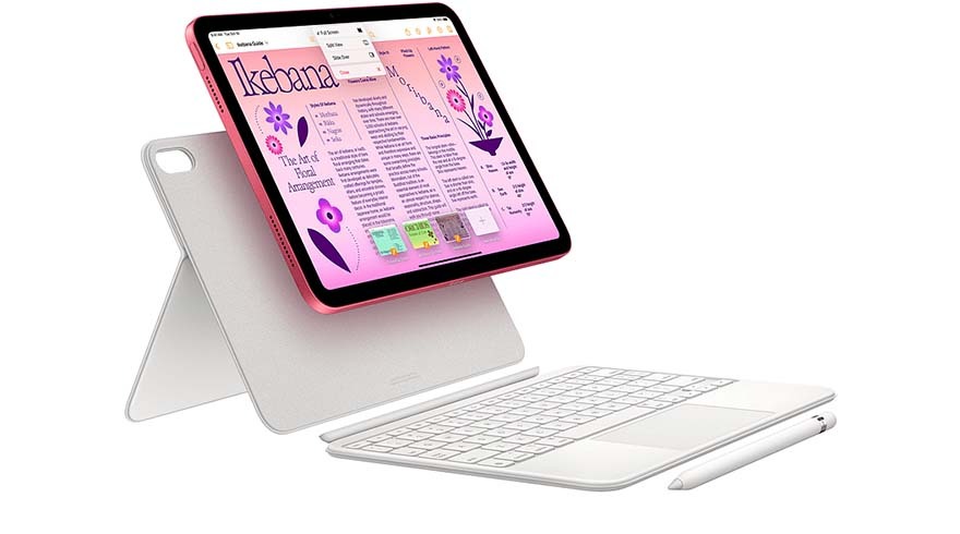 Een tablet met roze rand staat op een witte standaard. Een wit toetsenbord en pen liggen ernaast op een witte achtergrond.