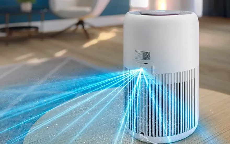 Witte luchtreiniger in een lichte kamer, met felle blauwe lichtstralen die van het toestel naar de vloer schijnen en stofdeeltjes opvangen.