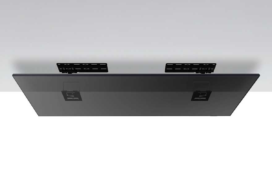 De achterkant van een zwart flatscreen-tv prominent onder een plafondbeugel, gezien vanuit een laag perspectief.