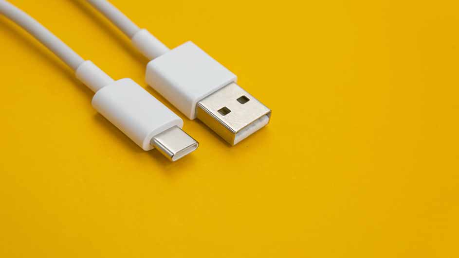 Witte USB-C- en USB-A-kabels liggen op een gele achtergrond.