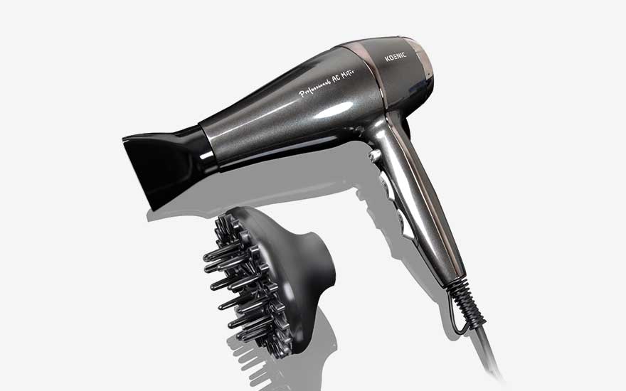 Shiny dark grey Koenic hairdryer placed at an angle, shown with a black diffuser covered in prongs to add volume and defined curls.