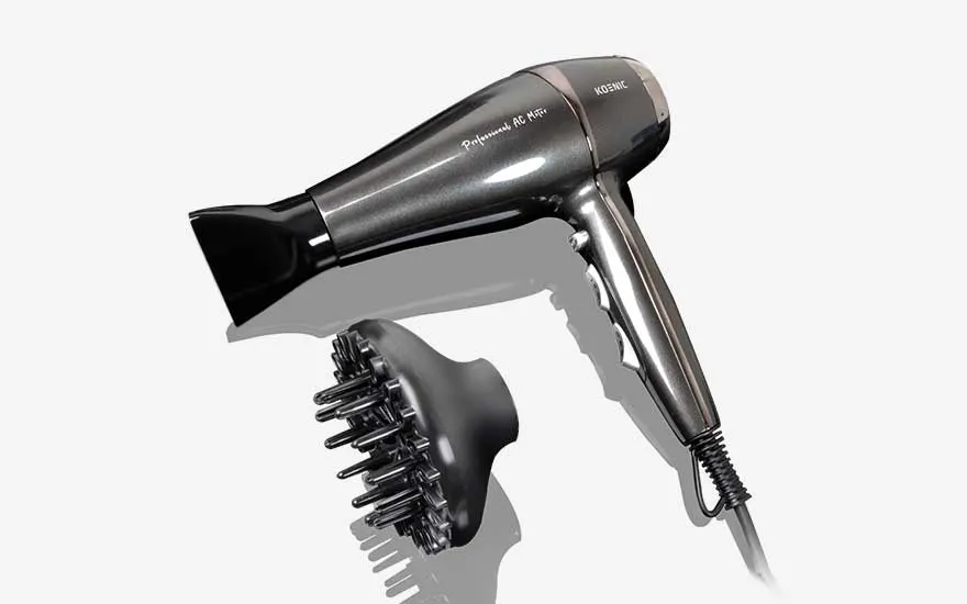 Shiny dark grey Koenic hairdryer placed at an angle, shown with a black diffuser covered in prongs to add volume and defined curls.