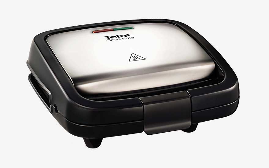 Gesloten Tefal tosti-ijzer met roestvrijstalen deksel en controlelampjes, compact ontwerp dat stabiel op het aanrecht staat.
