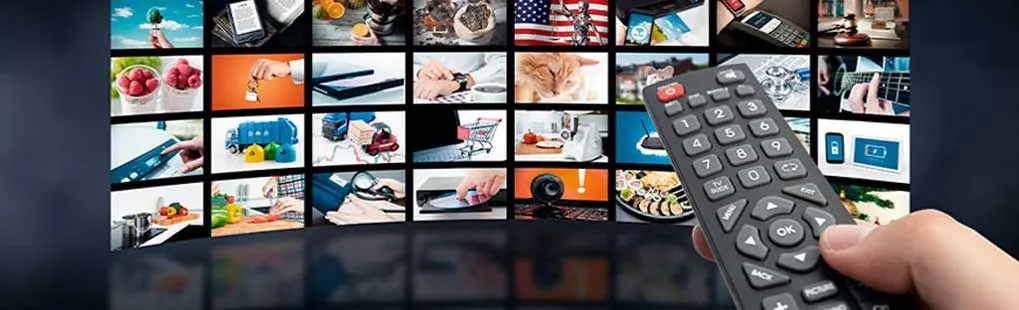 A hand holds a remote control in front of a curved display of various images, including objects, landscapes, and activities.