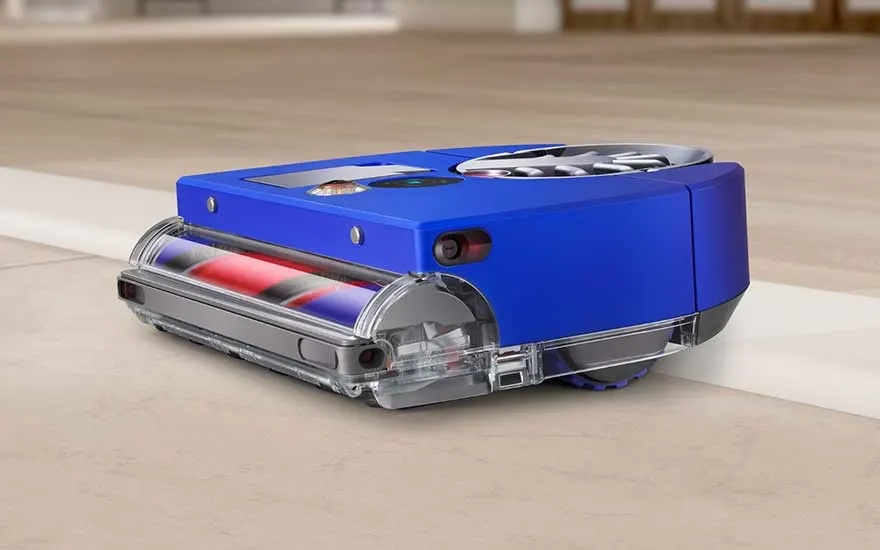 Een blauwe robotstofzuiger reinigt nauwkeurig langs de rand van een harde vloer, ideaal voor automatisch schoonmaken.