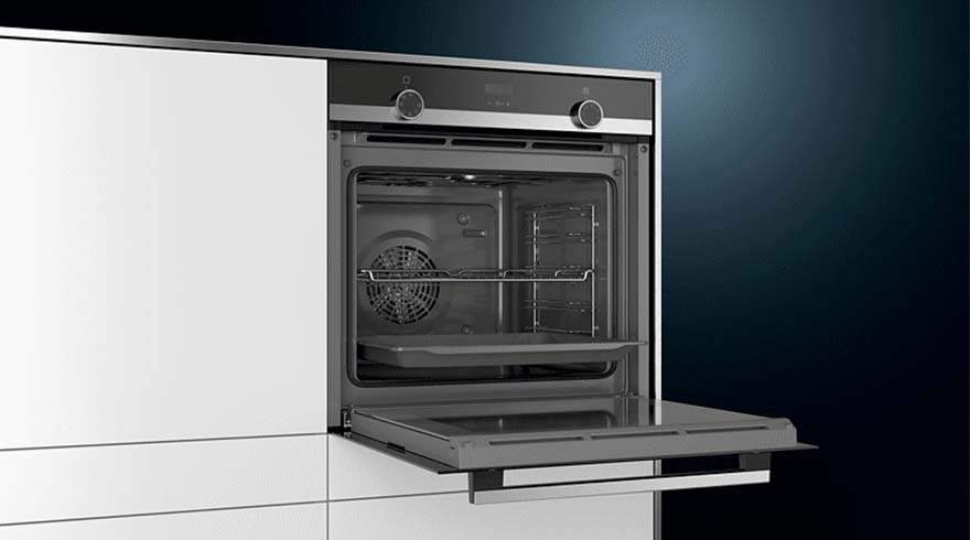 Open inbouw oven met witte kast, donkere rand en bedieningspaneel. Binnenin ventilator, rooster en bakplaat.