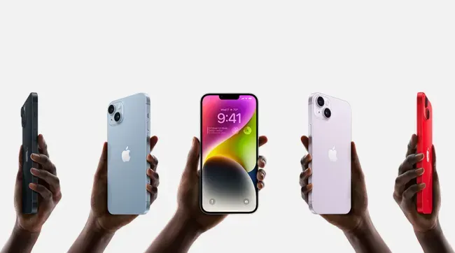 Vijf handen tonen iPhones in zwart, blauw, paars, wit en rood tegen een witte achtergrond.