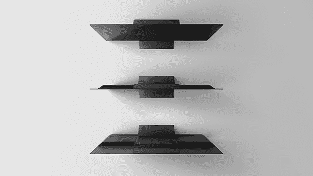 Drie grijze, horizontale planken van metaal zijn aan een witte muur bevestigd, met een rechthoekige steun aan de achterkant.