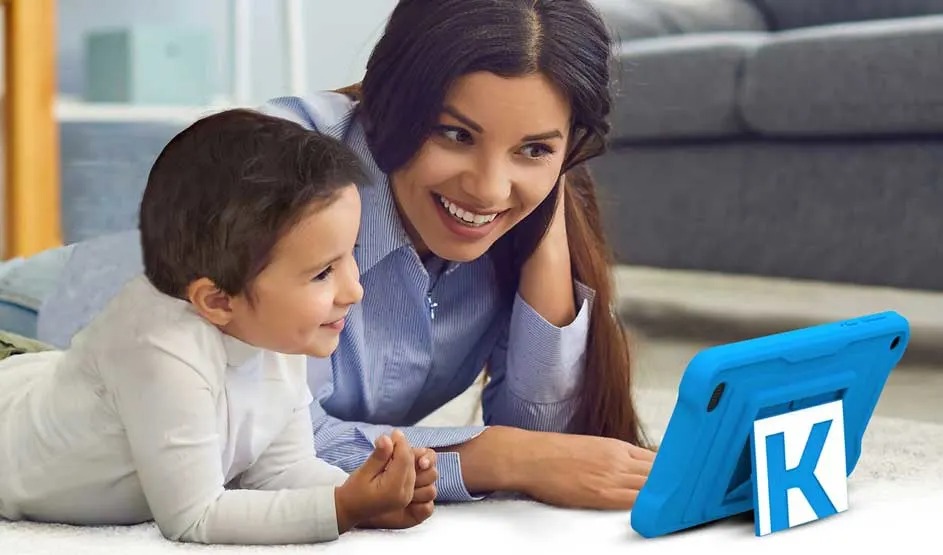 A child and an adult are lying together on the floor looking at a blue Kurio children's tablet with a stand. Brand: Kurio.