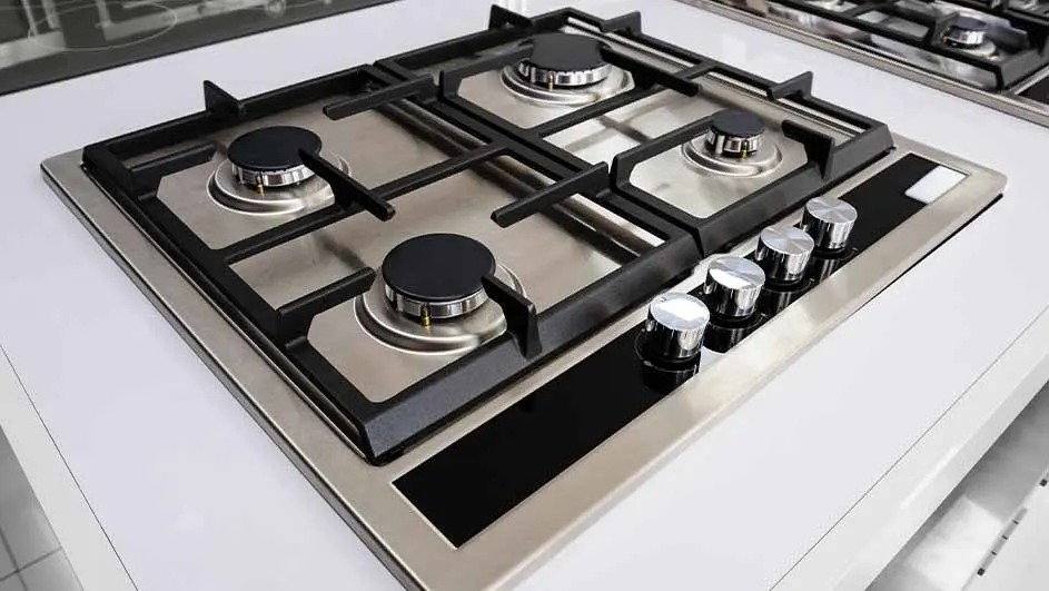 Inbouw gaskookplaat van roestvrij staal met vier branders, gietijzeren pandragers en vier chromen draaiknoppen aan de rechterzijde.