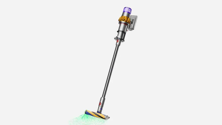 Een zilverkleurige Dyson stofzuiger staat diagonaal op een witte achtergrond, met groene verlichting onder de borstel.