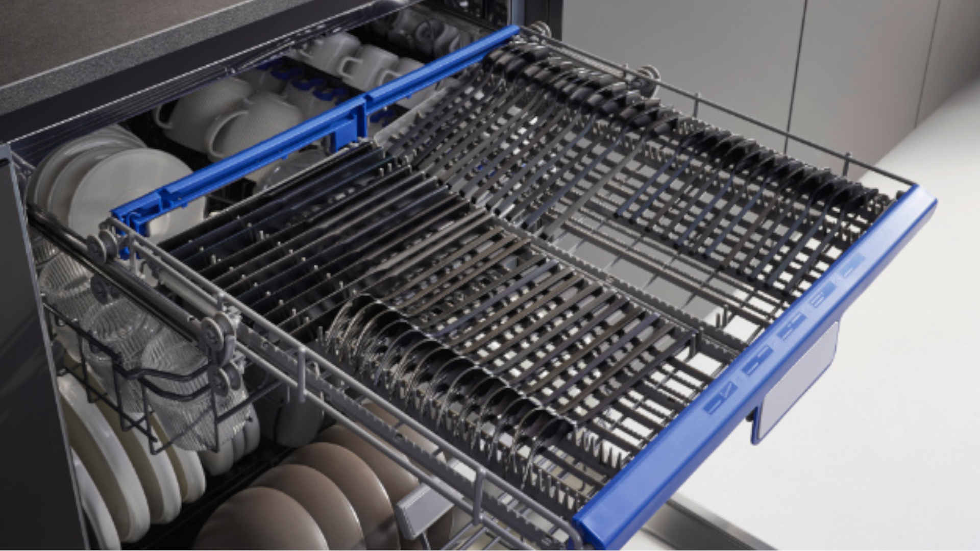 Besteklade en beladen korven in de geopende KOENIC vaatwasser KDW 6051-1 C FI in een moderne keuken.