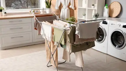 Wäsche trocknet auf einem Wäscheständer in einem modernen Waschraum