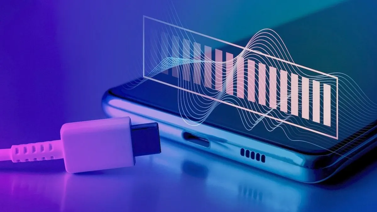 USB-C-Ladekabel liegt vor einem Smartphone mit grafischem Akku Symbol auf lila blauem Hintergrund.