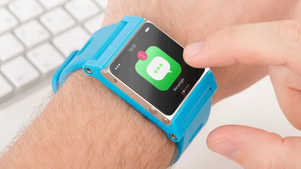 Hand tippt auf das Display einer blauen Smartwatch und geöffneter Messenger-App.