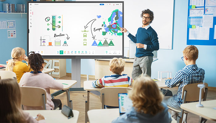 Ein interaktives Großformat Display von iiyama in einer Schule. Der Lehrer bedient das Display mit einem Stift.