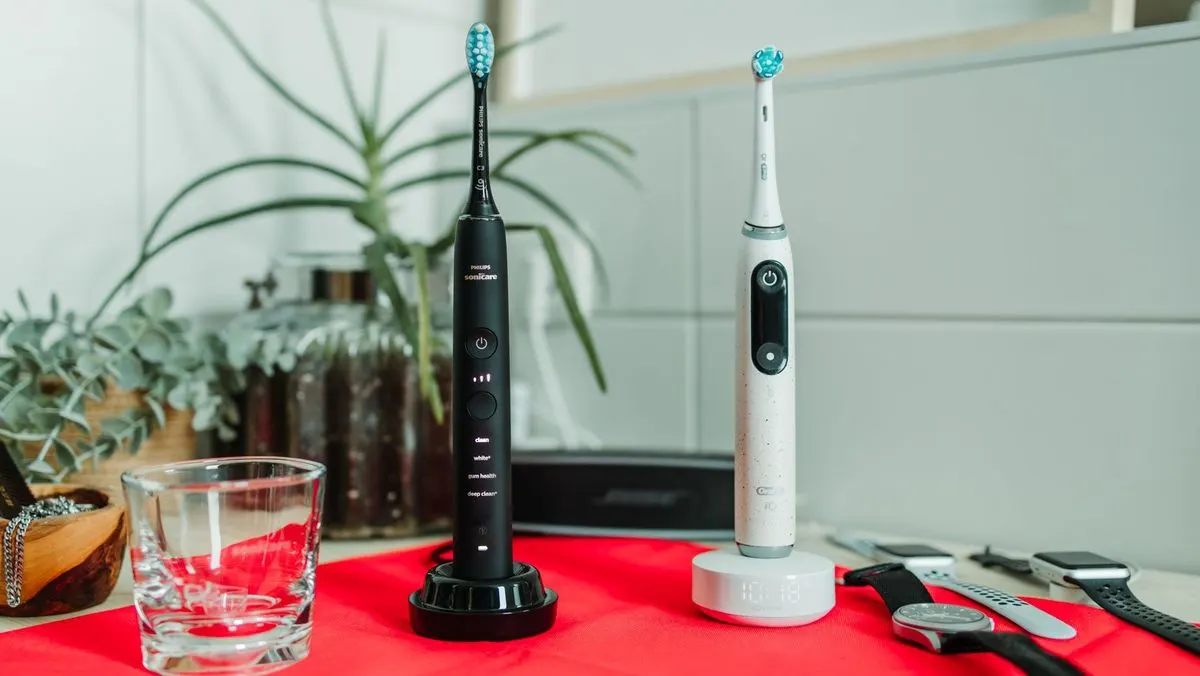 Elektrische Zahnbuersten von Philips und Oral B stehen nebeneinander im Badezimmer