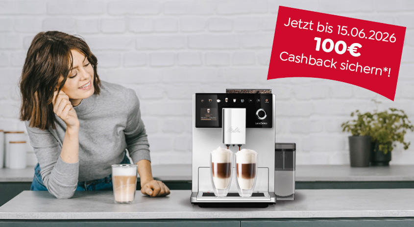 Zwei Frauen mit Latte Macchiato neben einem Kaffeevollautomaten. Rotes Schild: "100 € Cashback bis 15.06.2026".