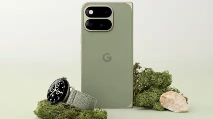 Google Pixel Smartphone in Olivgrün mit markanter Doppelkamera-Leiste, daneben eine Pixel Watch mit Textilarmband auf Moos-Dekoration.