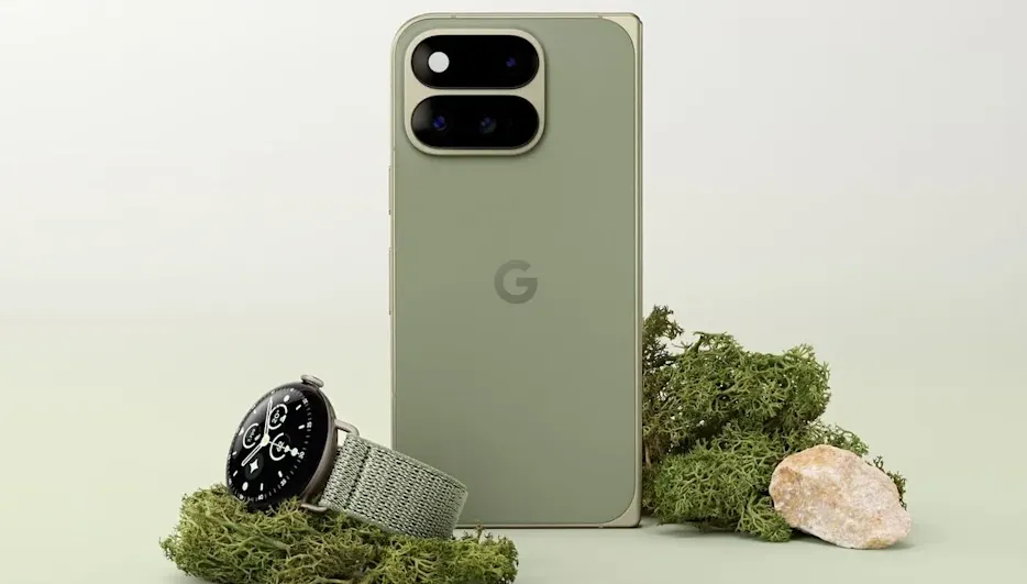 Google Pixel Smartphone in Olivgrün mit markanter Doppelkamera-Leiste, daneben eine Pixel Watch mit Textilarmband auf Moos-Dekoration.