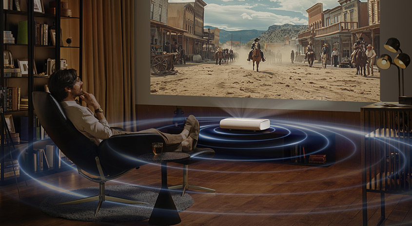 Ein Raum mit einem Projektor, der einen Westernfilm zeigt. Blaue Kreise symbolisieren den Klang. Bücherregal und Lampe im Raum.