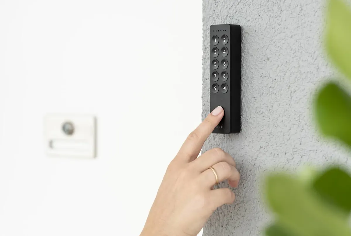 Eine Hand legt auf dem Nuki Keypad 2 den Finger auf den Fingerabdrucksensor.