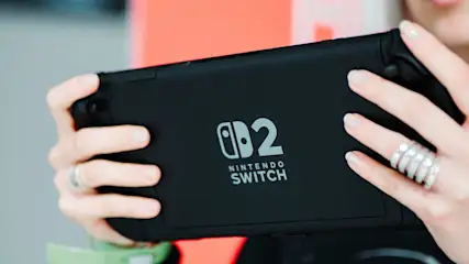 Person hält eine schwarze Nintendo Switch 2 Konsole in beiden Händen.
