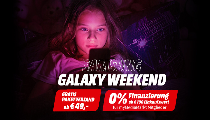 Ein Mädchen sitzt im Dunkel und schaut auf ihr Smartphone.