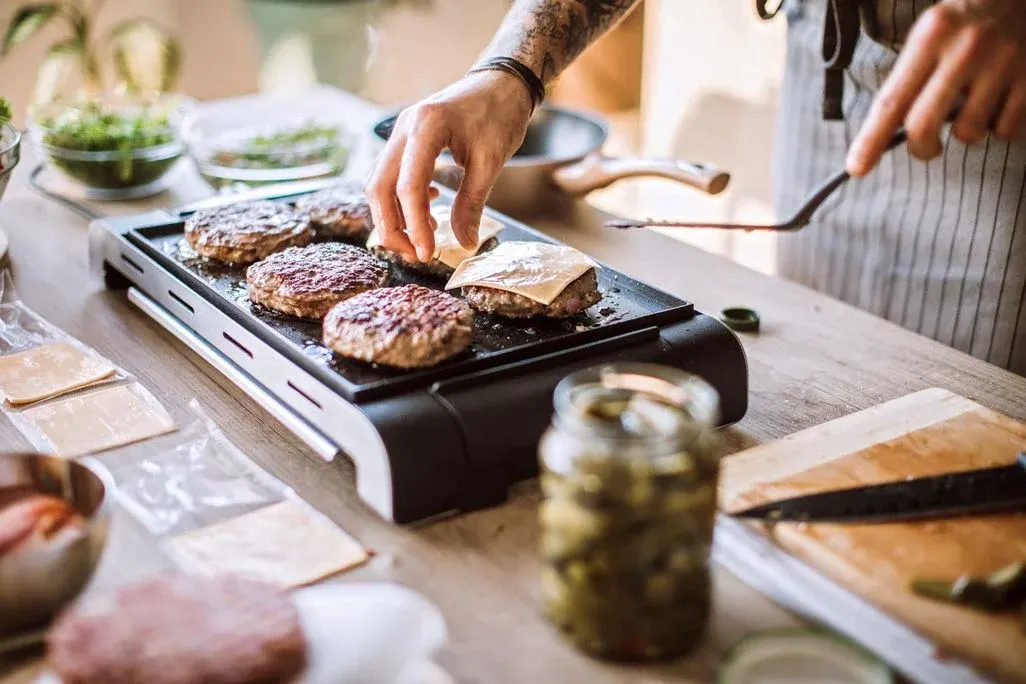 Elketrogriller mit Hamburger Leibchen darauf, manche mit Käse