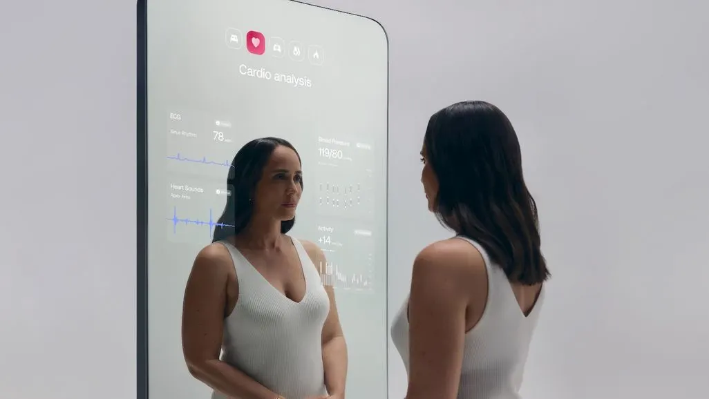 Eine Frau steht vor einem digitalen Fitnessspiegel mit angezeigten Gesundheitsdaten.