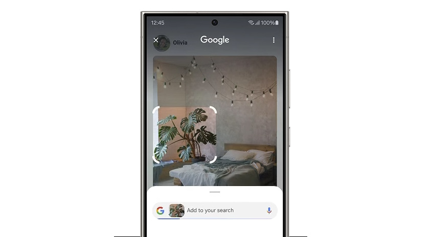 Auf einem Smartphone-Bildschirm wird eine Google-Suchoberfläche über einem Foto von einem Schlafzimmer mit einer grünen Zimmerpflanze angezeigt.