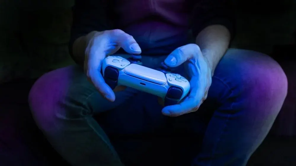 Hände im Dunklen blau beleuchtet steuern Controller