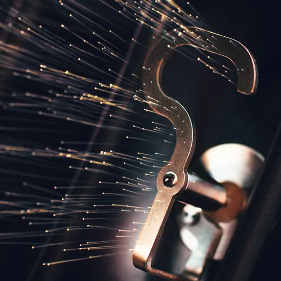 Nahaufnahme eines Türgriffs aus Metall mit dekorativen Lichtfasern vor einem dunklen Hintergrund.