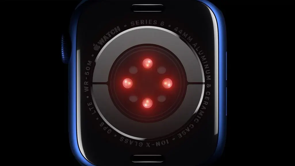 Rückseite einer Apple Watch Series 6 (44 mm) mit leuchtenden roten Sensoren zur Herzfrequenz- und Blutsauerstoffmessung.