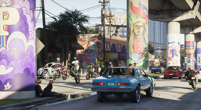 Eine Straße in Vice City, auf der Autos fahren und Leute mit Dirtbikes und Quads Tricks ausführen.
