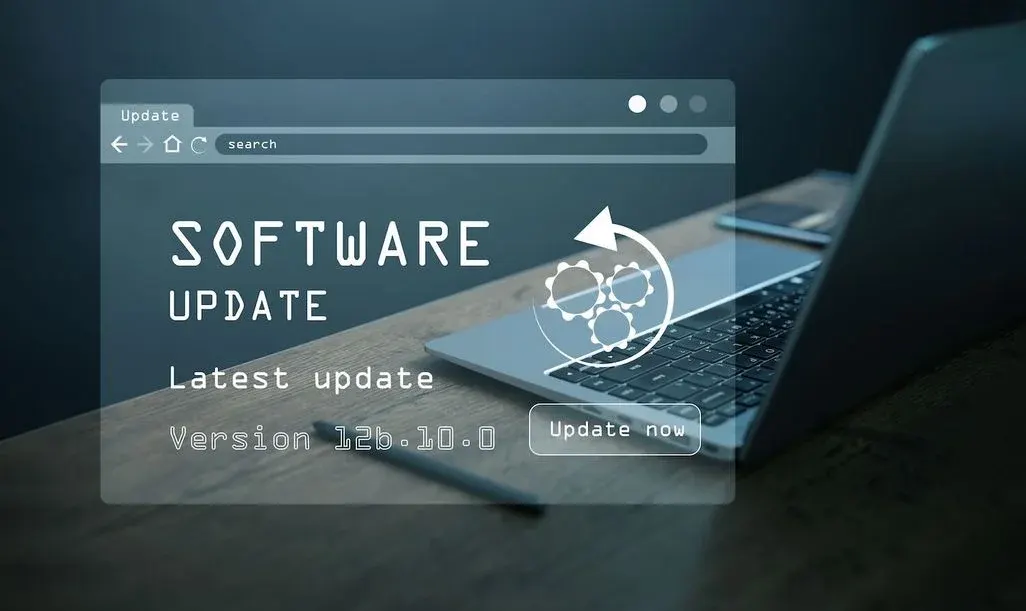 Laptop auf Schreibtisch mit eingeblendeter Meldung „Software Update – Latest update Version 12b.10.0“ und Schaltfläche „Update now“.