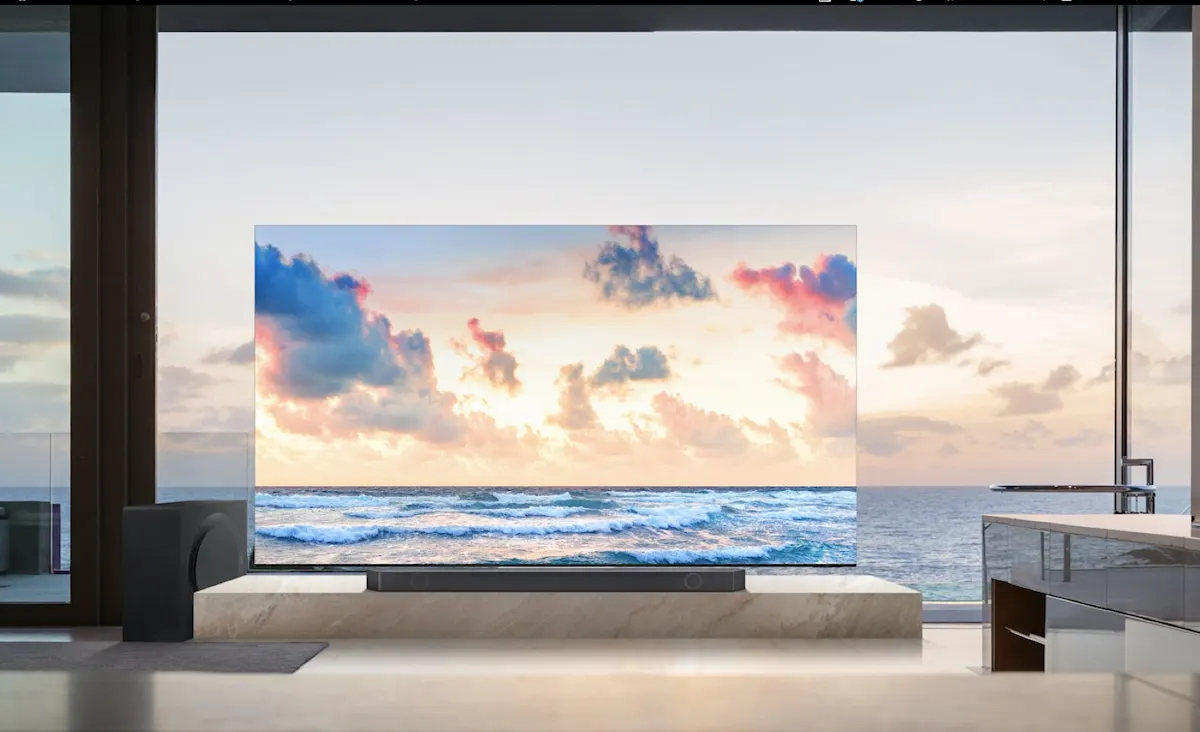 Geräumiges Wohnzimmer mit großem Fernseher und Meerblick durch Panoramafenster.