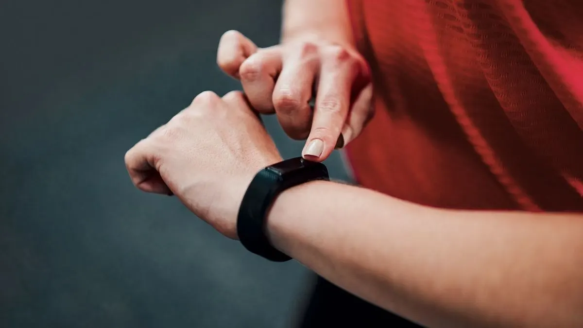 Eine Frau bedient einen Fitness-Tracker am Handgelenk.