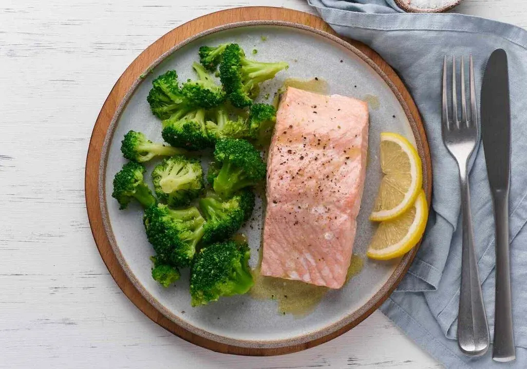Bild von einem Teller mit einem Lachsfilet, Brokkoli und Zitronenscheiben