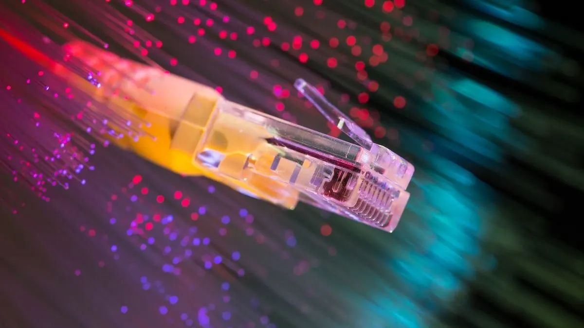 Nahaufnahme eines Netzwerkkabels vor bunt leuchtenden Fasern