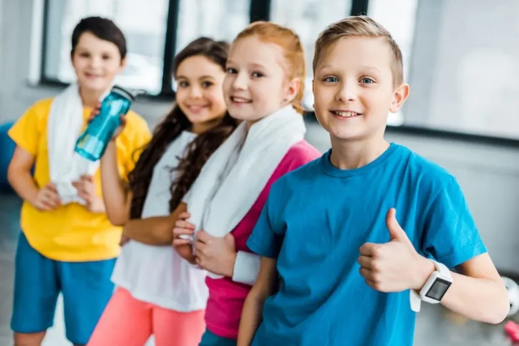 Schülerinnen und Schüler stehen in einer Reihe hintereinander und der vorderste trägt eine Smartwatch für Kinder.Smartwatch für Kinder