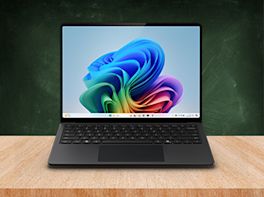 Laptop mit buntem Windows-Desktop steht auf einem Holztisch.